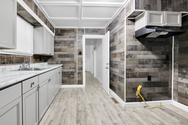 interior space with visible vents, a sink, wood finished floors, wooden walls, and baseboards