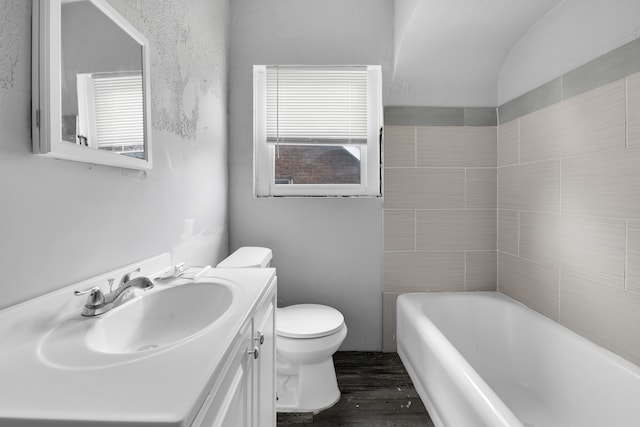 full bathroom featuring a bath, toilet, vanity, and wood finished floors