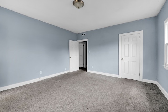 unfurnished bedroom featuring visible vents, baseboards, and carpet