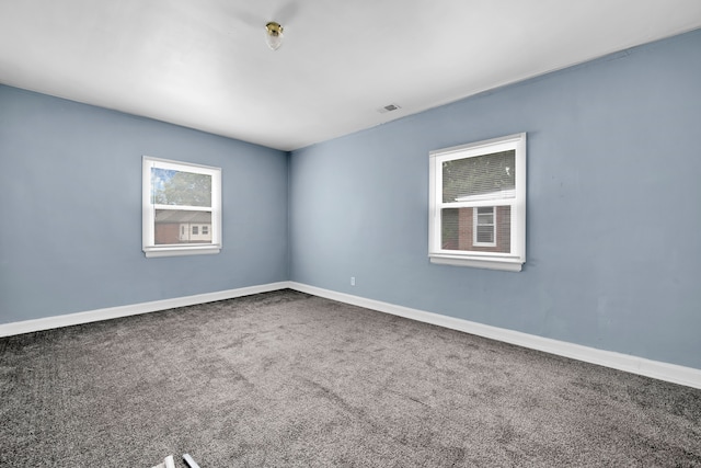 spare room with visible vents, baseboards, and carpet