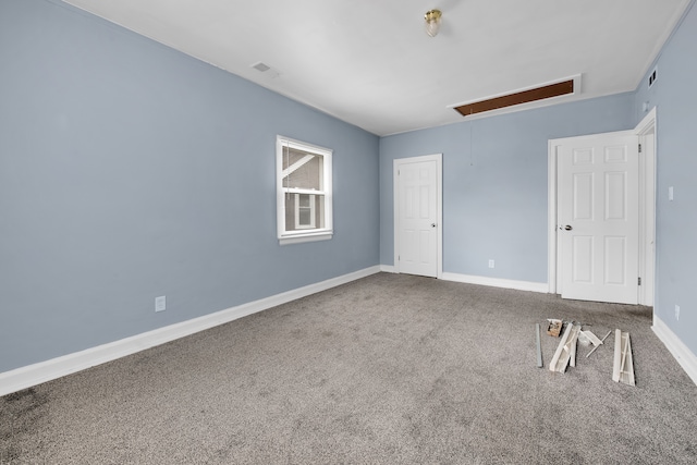 unfurnished bedroom with attic access, baseboards, visible vents, and carpet floors