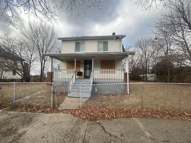 view of front of property with a fenced front yard, covered porch, a chimney, and a gate