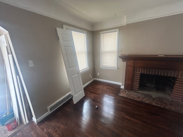 unfurnished living room with visible vents, baseboards, wood finished floors, and crown molding