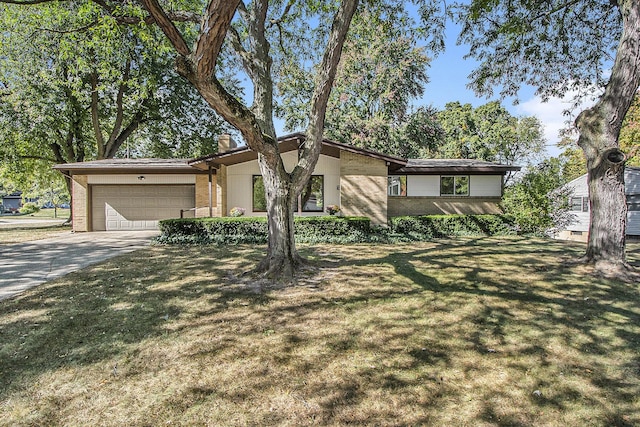 mid-century modern home featuring brick siding, driveway, a front lawn, and a garage