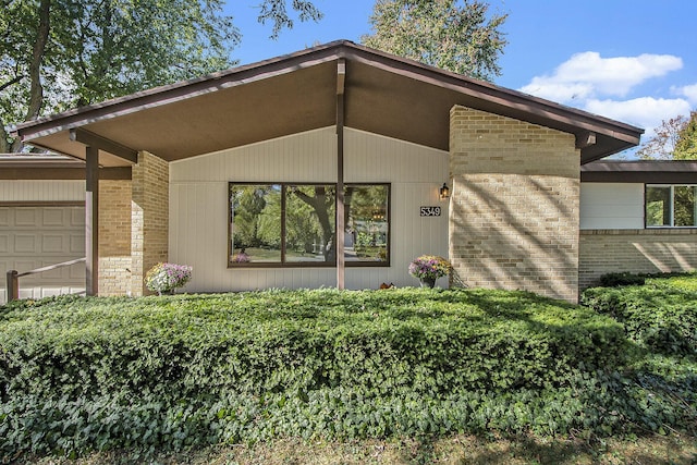 property entrance featuring brick siding and an attached garage