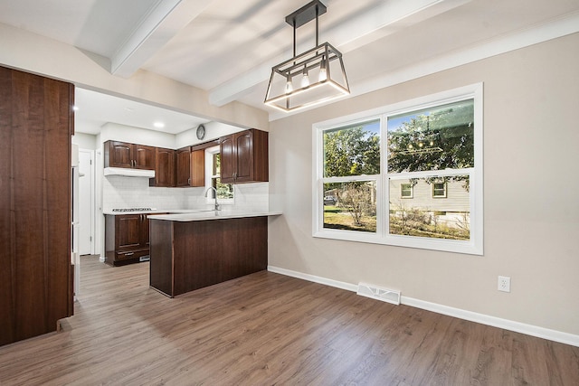 kitchen featuring visible vents, beamed ceiling, tasteful backsplash, dark brown cabinetry, and baseboards