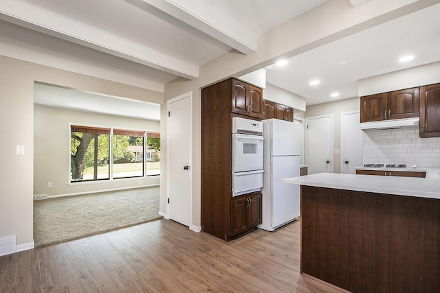 kitchen featuring a warming drawer, decorative backsplash, white appliances, and dark brown cabinets