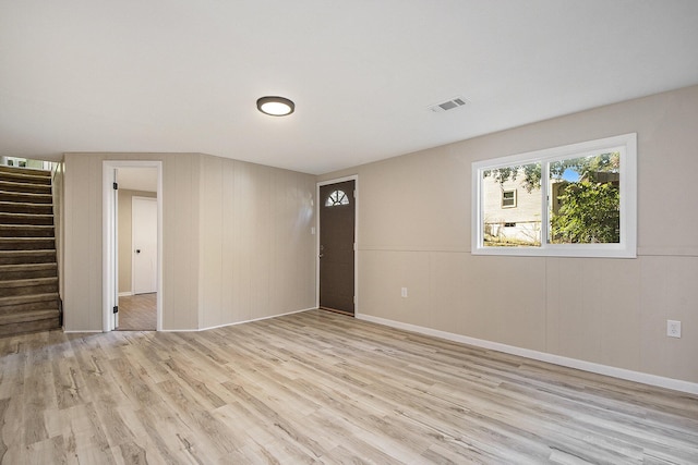 spare room featuring visible vents, stairway, and light wood-style floors