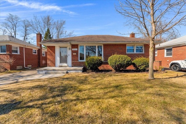 ranch-style home featuring a front yard, brick siding, and a chimney