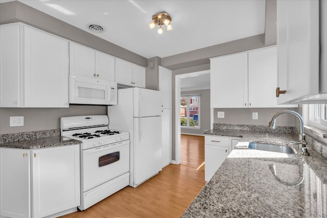 kitchen featuring a sink, white appliances, and white cabinetry