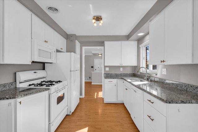 kitchen featuring white appliances, visible vents, a sink, light wood-style floors, and white cabinetry