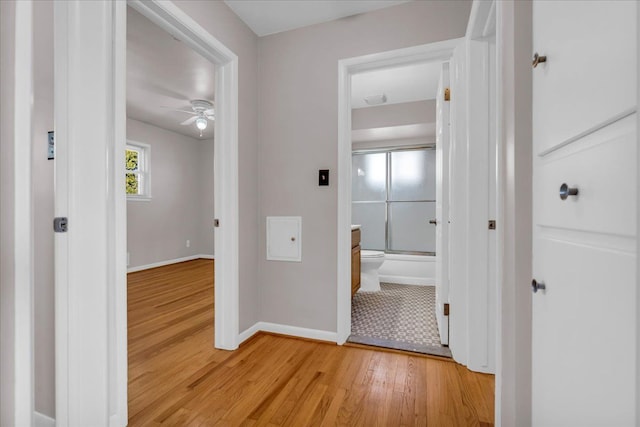 hallway with light wood-style flooring and baseboards