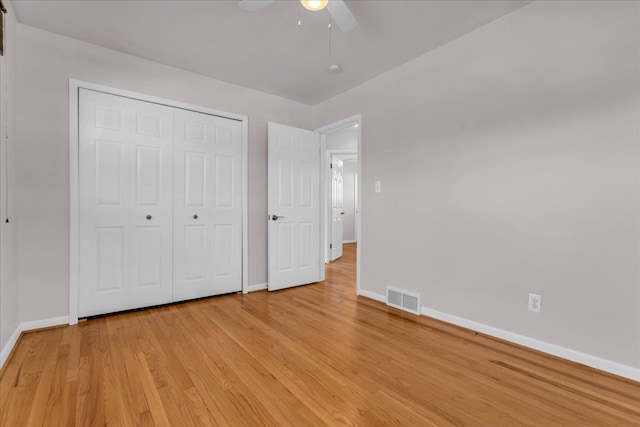 unfurnished bedroom with visible vents, baseboards, light wood-style floors, and a closet