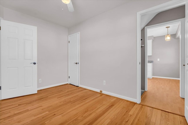 unfurnished bedroom with light wood-type flooring, baseboards, and ceiling fan