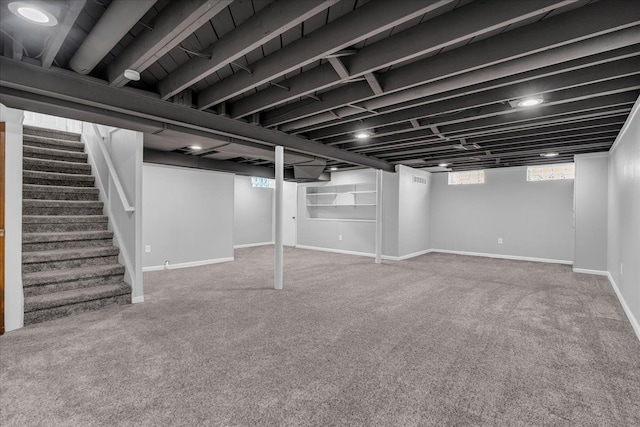 basement featuring carpet flooring, stairs, and baseboards