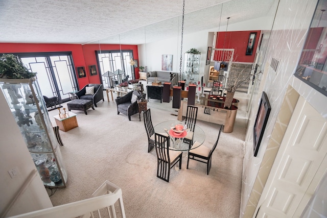 dining area with vaulted ceiling, carpet flooring, and a textured ceiling