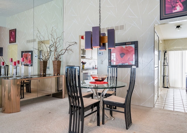 dining space with wallpapered walls, visible vents, carpet floors, and a textured ceiling