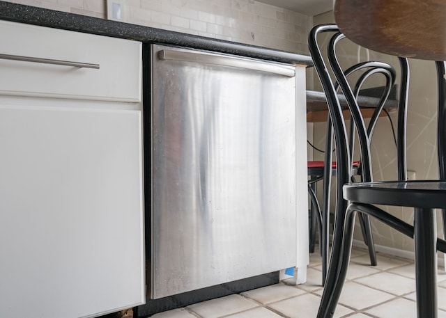 room details featuring stainless steel dishwasher and dark countertops