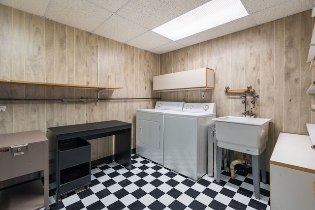 clothes washing area featuring tile patterned floors, wooden walls, cabinet space, and separate washer and dryer