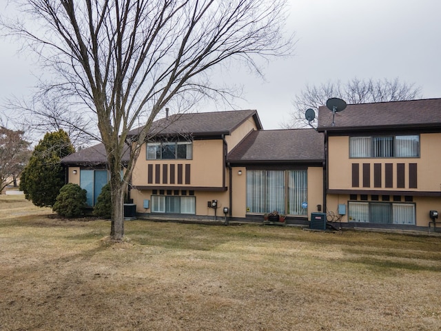 back of house with a yard, central AC, and stucco siding