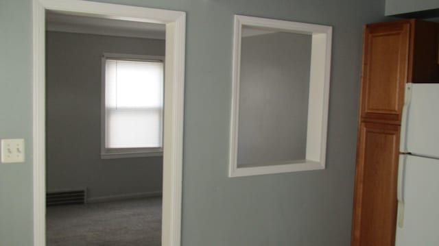 corridor featuring visible vents, baseboards, and carpet flooring