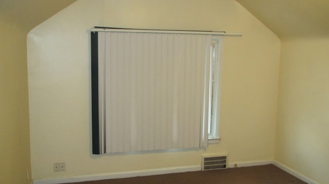 spare room with visible vents, lofted ceiling, and baseboards