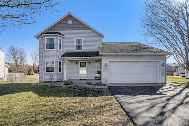 traditional-style house featuring a front lawn, an attached garage, fence, and driveway