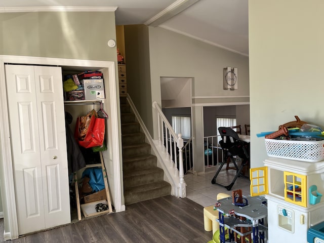 staircase with lofted ceiling with beams, wood finished floors, and crown molding