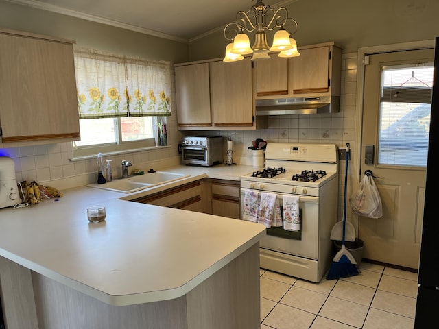 kitchen with light countertops, white gas range oven, under cabinet range hood, and light brown cabinetry