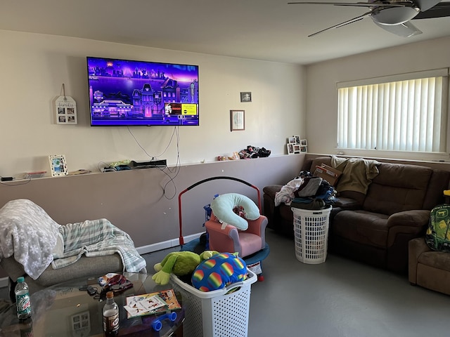 living area with concrete floors and ceiling fan