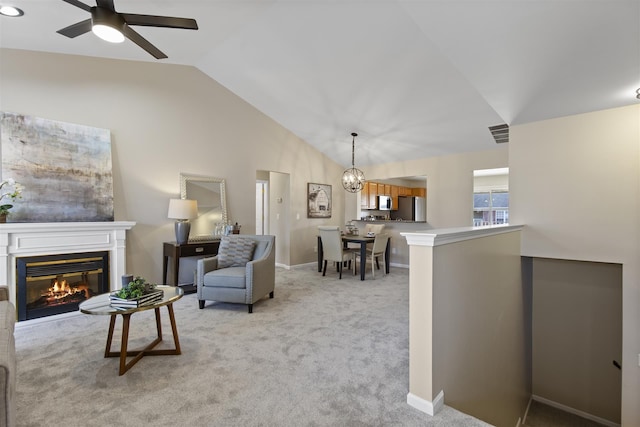 living room with visible vents, light carpet, a glass covered fireplace, baseboards, and ceiling fan