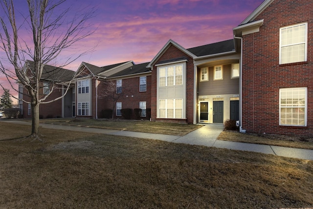 view of front facade with a front lawn and brick siding