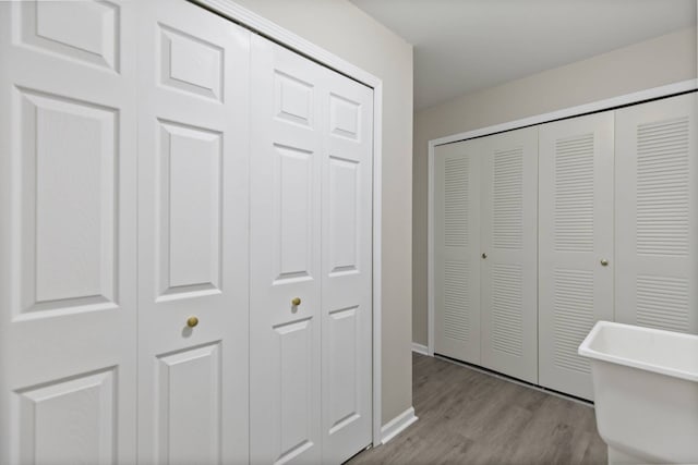 interior space featuring wood finished floors, a closet, and baseboards