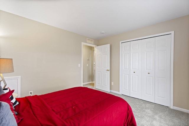 carpeted bedroom featuring baseboards, visible vents, and a closet