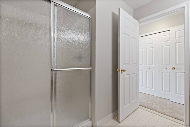 full bath with tile patterned flooring, a stall shower, and baseboards