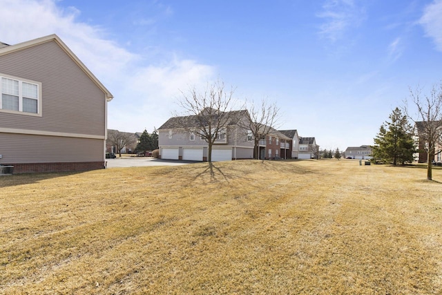 view of yard with a garage and driveway