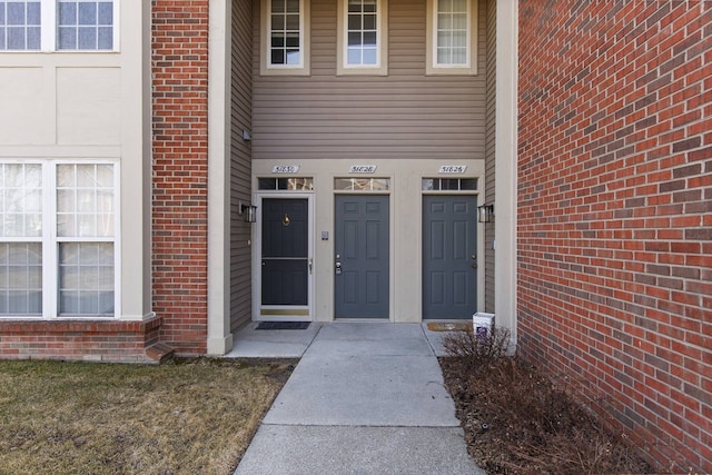 entrance to property featuring brick siding