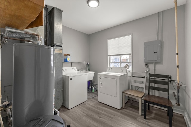 clothes washing area with washing machine and clothes dryer, light wood-type flooring, electric panel, laundry area, and a sink