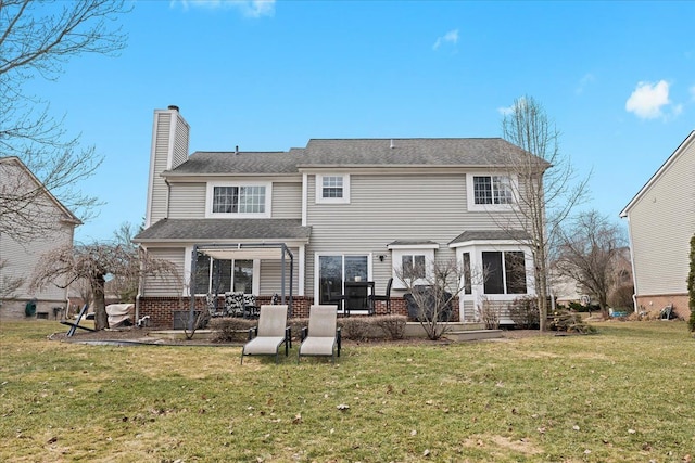 rear view of property with a yard and a chimney