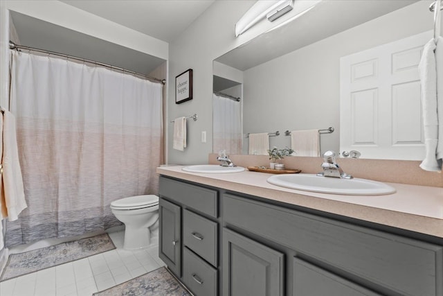 bathroom with a sink, toilet, double vanity, and tile patterned flooring