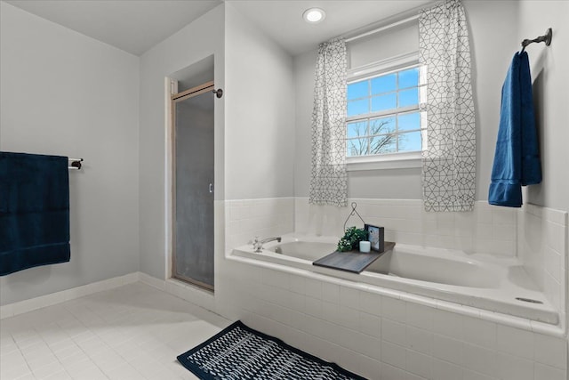 full bathroom with tile patterned flooring, a bath, baseboards, and a stall shower