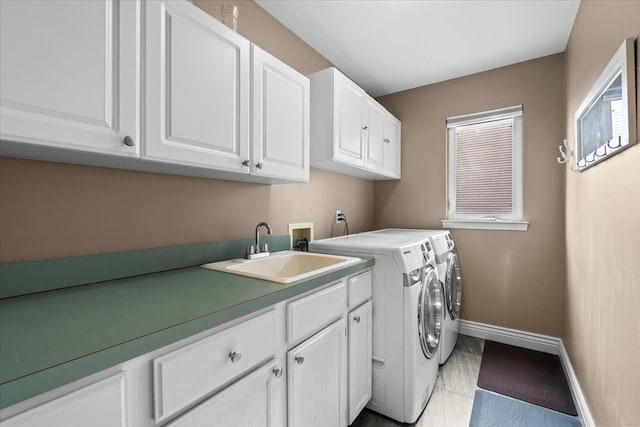 laundry room featuring a sink, baseboards, cabinet space, and washing machine and clothes dryer