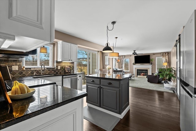 kitchen with backsplash, dishwasher, white cabinetry, a ceiling fan, and a sink