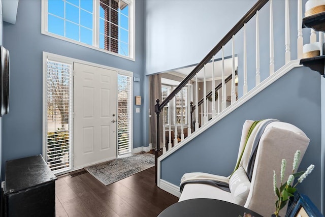 entrance foyer featuring baseboards, stairs, a high ceiling, and hardwood / wood-style floors