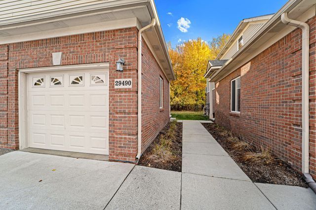 view of side of property featuring a garage and brick siding