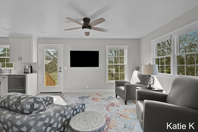 living room featuring a ceiling fan and baseboards