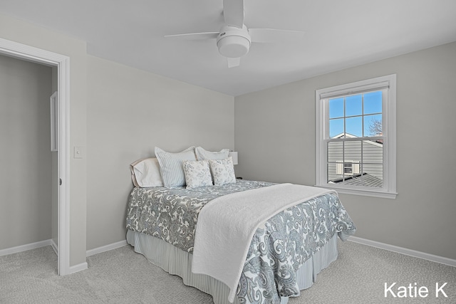 bedroom featuring light colored carpet, baseboards, and ceiling fan