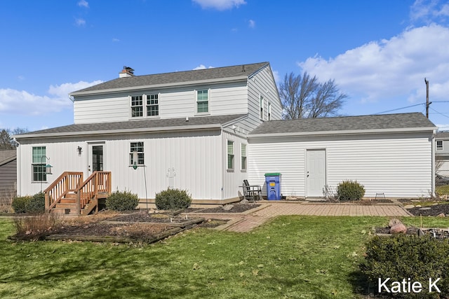 back of house featuring a patio, a lawn, a chimney, and a shingled roof