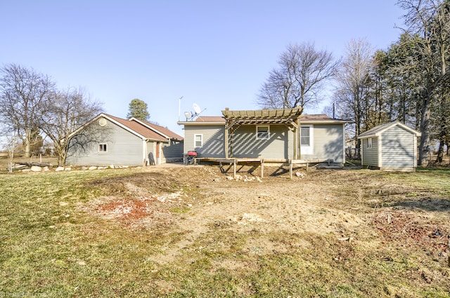 rear view of property featuring an outbuilding, a storage unit, and a pergola