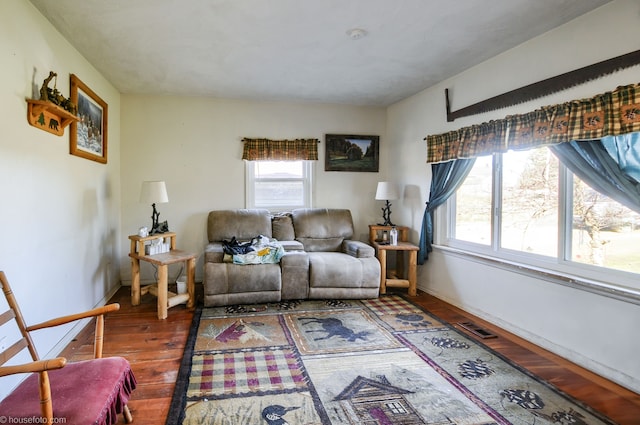 living room with visible vents, baseboards, and wood finished floors